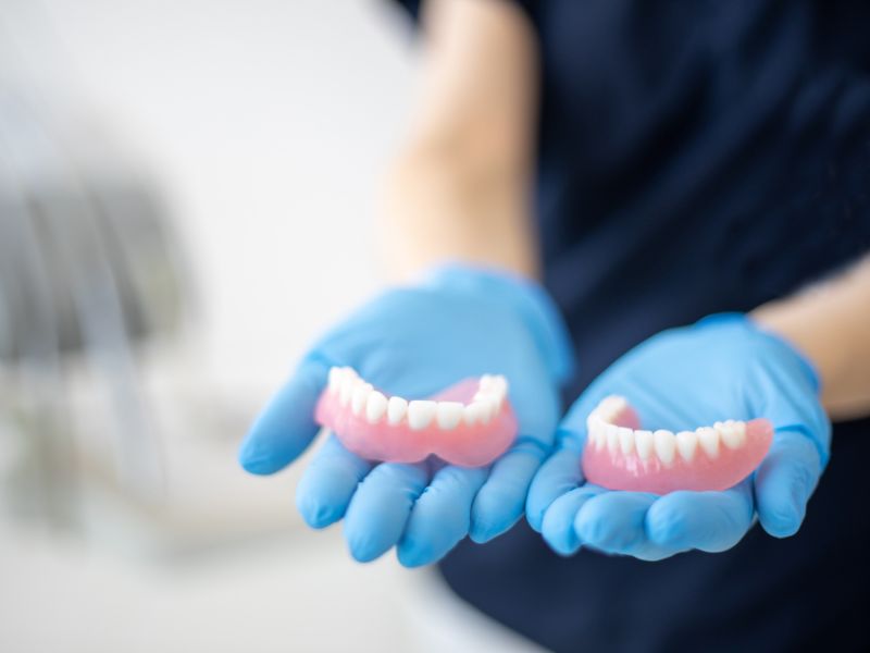 A dentist holding full dentures.