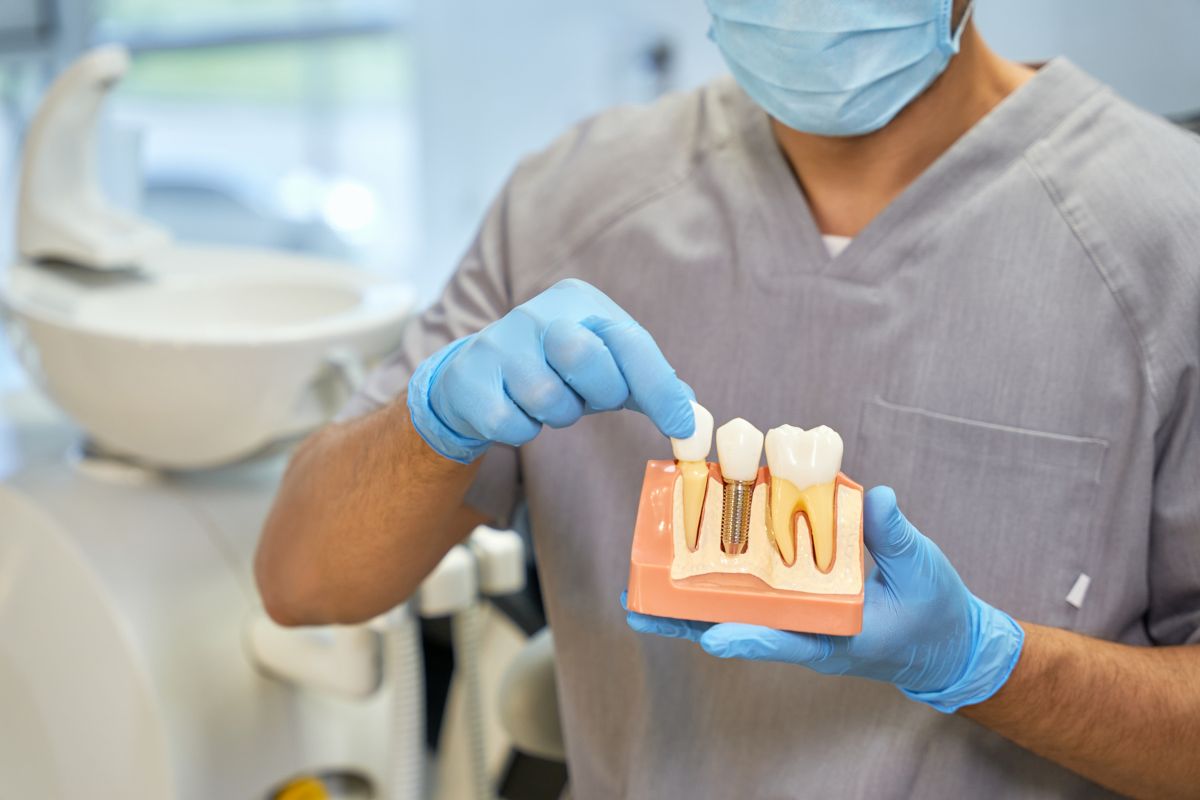 dental technician showing anatomy of dental implant.